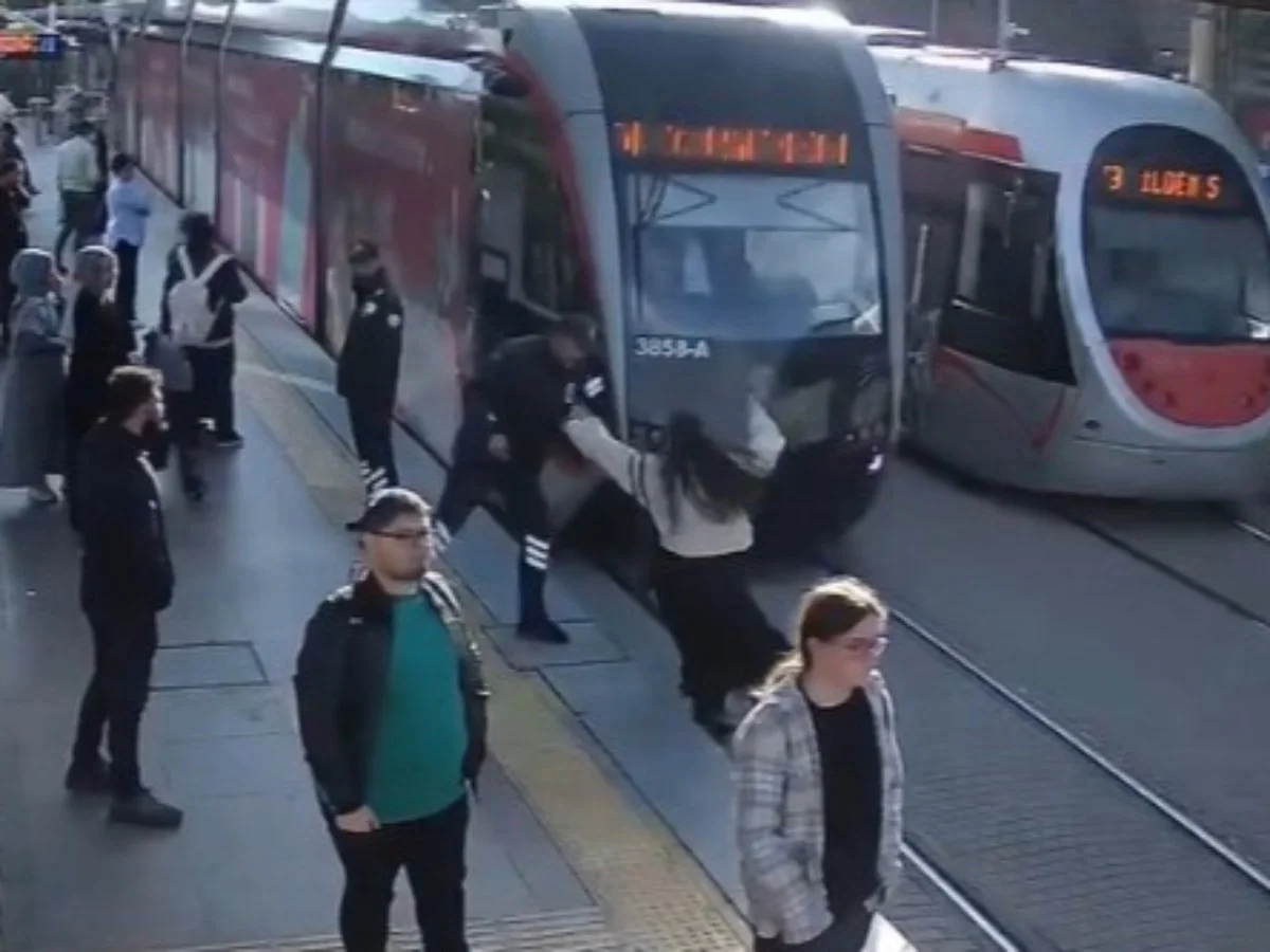 Az kalsın tramvayın altında kalıyordu! Güvenlik görevlisi genç kızı kurtardı.